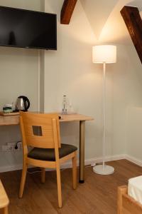 een kamer met een tafel, een stoel en een lamp bij Hotel Alter Kreisbahnhof in Schleswig