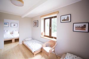 Zimmer mit 2 Betten, einem Stuhl und einem Fenster in der Unterkunft Swoboda na końcu świata in Brenna