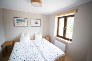 Schlafzimmer mit einem Bett und einem Fenster in der Unterkunft Swoboda na końcu świata in Brenna
