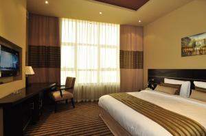 Postel nebo postele na pokoji v ubytování Aldar Hotel