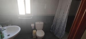 a bathroom with a white toilet and a sink at Casa Clavel in Ronda