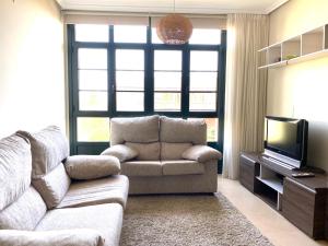 a living room with a couch and a television at Barreiros Playa Altar in Barreiros