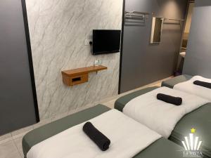 a hotel room with two beds and a mirror at Malim Melaka Homestay in Melaka