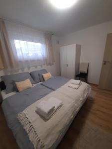 sypialnia z dużym łóżkiem z dwoma ręcznikami w obiekcie Opál Apartman w Nyíregyházie