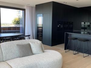 a living room with a white couch and a kitchen at appartement sea view in Ostend +21 photos