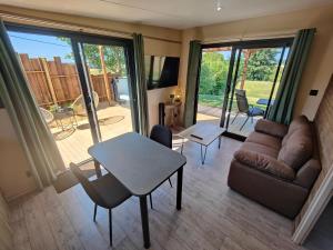 a living room with a couch and a table at Domaine des graminées in Jeanménil
