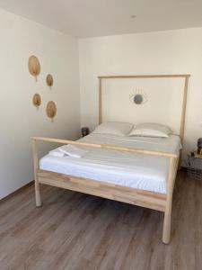 Cette chambre comprend un lit avec un cadre en bois. dans l'établissement Hôtel boutique Quai d'Azur, au Grau-du-Roi