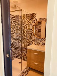 La salle de bains est pourvue d'une douche et d'un lavabo. dans l'établissement Hôtel boutique Quai d'Azur, au Grau-du-Roi