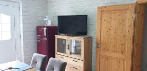a living room with a television on a wooden cabinet at Wanderstube Landsonne in Simmerath