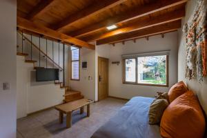 ein Wohnzimmer mit einem Sofa und einem Tisch in der Unterkunft Balcones del Sayhueque in Villa La Angostura