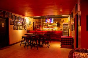 a restaurant with a bar with tables and chairs at Klub Afriko Hotel Arusha in Arusha