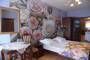 1 dormitorio con un mural de rosas en la pared en Hotelik Pod Lwami en Małaszewicze Duże
