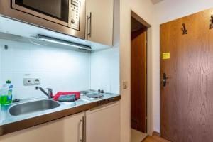 a kitchen with a sink and a microwave at Studio Bergblick in Inzell +12 photos