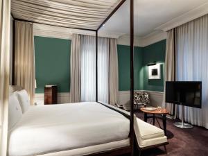 a bedroom with a large bed and a television at J.K. Place Roma - The Leading Hotels of the World in Rome