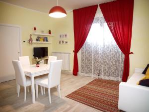 a dining room with a white table and white chairs at Appartamenti Pistrella in Orvieto