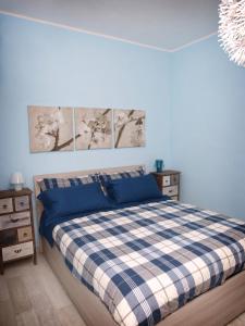 a bedroom with a blue and white plaid bed at Appartamenti Pistrella in Orvieto