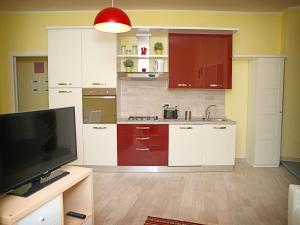 a kitchen with white cabinets and a flat screen tv at Appartamenti Pistrella in Orvieto