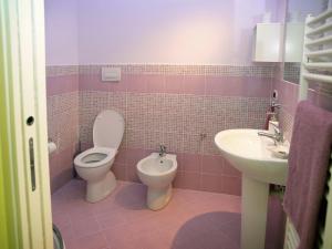 Baño de color rosa con aseo y lavamanos en Appartamenti Pistrella, en Orvieto