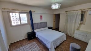 ein Schlafzimmer mit einem weißen Bett und einem Fenster in der Unterkunft Midpoint Sea View - families only in Alexandria