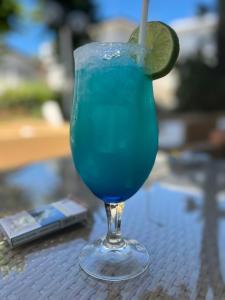 a blue drink with a lime on a table at HOTEL TRIESTE in Riccione
