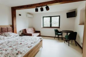 een slaapkamer met een bed en een tafel en stoelen bij Skava Apartments Zator Energylandia in Wadowice