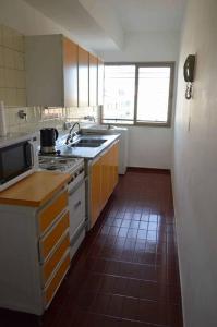 een keuken met een wastafel en een fornuis top oven bij Departamento céntrico y confortable in Mendoza