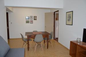 een woonkamer met een houten tafel en stoelen bij Departamento céntrico y confortable in Mendoza