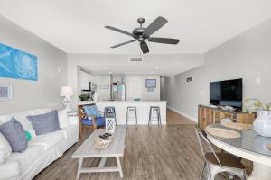 a living room with a white couch and a ceiling fan at Majestic Beach Towers 1-1006 in Panama City Beach