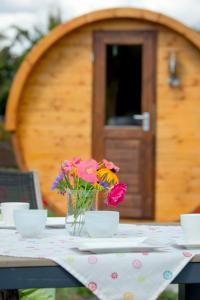 Una mesa con flores en un jarrón. en Schlaffass Campingplatz Nordbrock en Hamminkeln