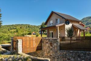 a house with a wooden fence in front of it at Bajka in Kolašin