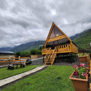 a large wooden cabin with a view of mountains at Cottage Carpe Diem in Stepantsminda