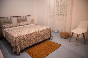a bedroom with a bed and a table and a chair at ACQUAMARINA APPARTAMENT in Procida