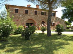 a large brick building with a tree in a yard at Agriturismo La Fraternita in Montepulciano