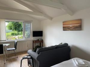 a living room with a couch and a table and a window at Spacious lodge with king sized bed in Inveraray