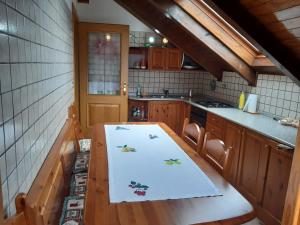 a kitchen with a wooden table with a towel on it at Mansarda Erika - appartamento in Zovello