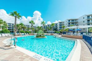 una piscina en el complejo con palmeras y apartamentos en condominio en Waterscape 235-A, en Fort Walton Beach