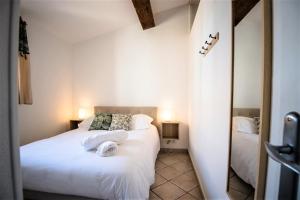 Bel appartement cosy au coeur de Cabestany في Cabestany: غرفة نوم بسريرين مع شراشف بيضاء ومرآة