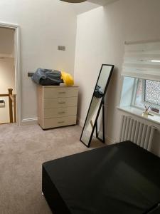 a bedroom with a dresser and a mirror and a dresser at City Centre Duplex Sleeps 4 #H9 in Hull