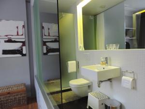 bagno con servizi igienici, lavandino e specchio di B&B Lodging At 8 a Lovanio