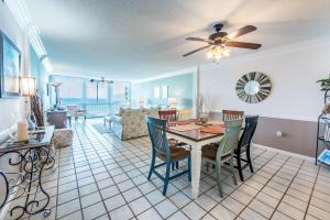 a dining room and living room with a table and chairs at Shoreline Towers 3074 in Destin
