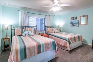 a bedroom with two beds and a ceiling fan at Shoreline Towers 3074 in Destin +28 photos