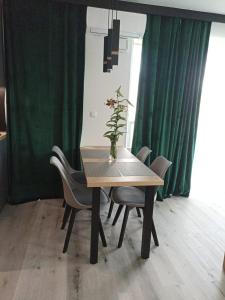a dining room table with chairs and a vase with a plant at Apartament Bernata-Śródka in Poznań