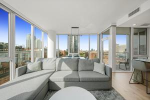 a living room with a couch and large windows at Level Chicago - River North in Chicago