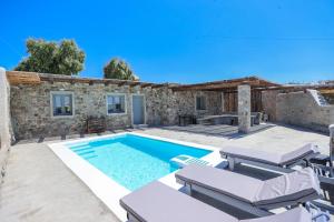 een villa met een zwembad en tuinmeubilair bij The George Villas Mykonos with Private Pool & Town Proximity in Mykonos-stad