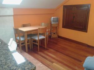 a room with a table and chairs and a tv at Apartamentos Cobrana in Valle de Lago