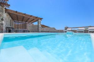 a large swimming pool in a villa at The George Villas Mykonos with Private Pool & Town Proximity in Mýkonos City