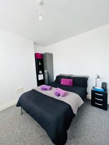 a bedroom with a large bed with purple pillows at Cinderhouse Highbury Vale in Nottingham
