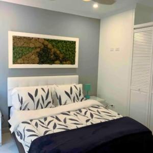 a bedroom with a bed and a painting on the wall at Family Apartment with Pool in Aruba in Palm-Eagle Beach +10 photos