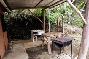 einem Picknicktisch und einer Bank auf einer Terrasse in der Unterkunft Cucú Ardilla Vivienda Campestre en Pance in Cali