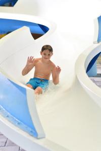 un joven sentado en un tobogán de agua en Holiday Inn Express Wisconsin Dells, an IHG Hotel, en Wisconsin Dells